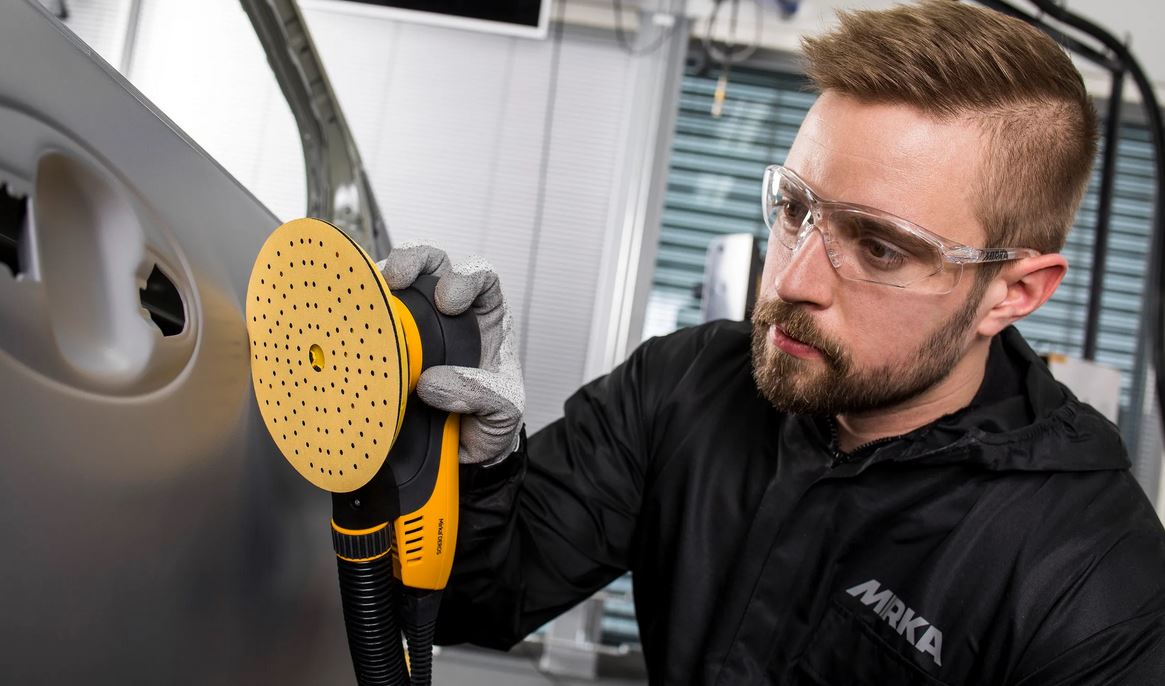 Abbildung Anwendung Mirka Gold 150mm 121L Scheibe mit Mirka Deros am Auto auf Lack.